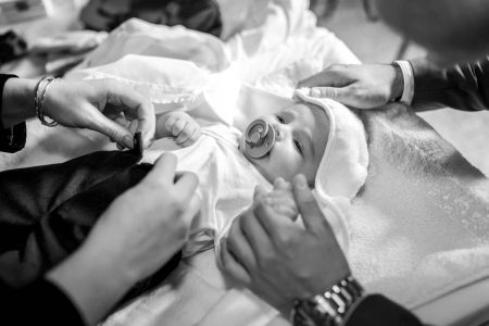 Bebelus imbracat dupa ce a fost botezat, cadru surprins in biserica de fotograf botez in bucuresti