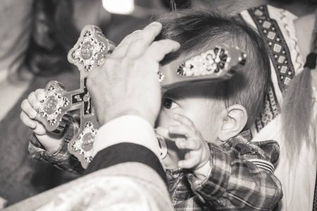 Fotograf Botez Bucuresti, bebelus incercand sa prinda mana preotului